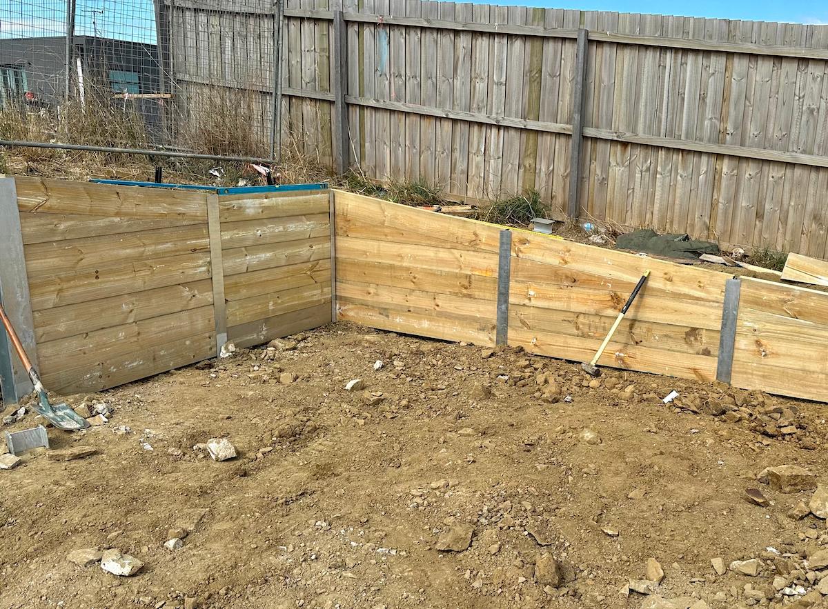 A classic timber retaining wall in a garden setting.